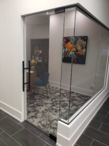 Sleek glass office partition with a frameless door, installed by Belka Glass in Toronto. Enhancing workspace with modern, transparent design and natural light flow.